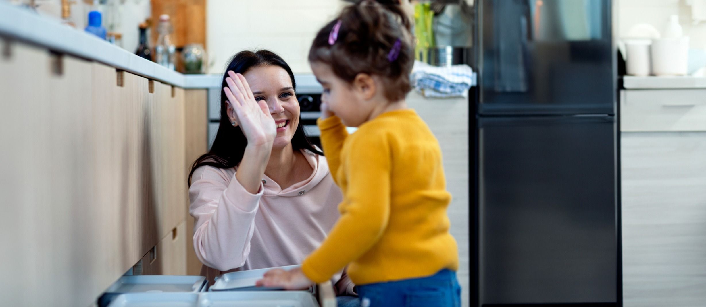 Picture - Mama i córka znajdują się w kuchni i przybijają sobie piątkę